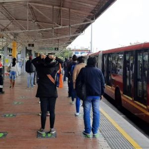 Personas haciendo fila para abordar un transmilenio